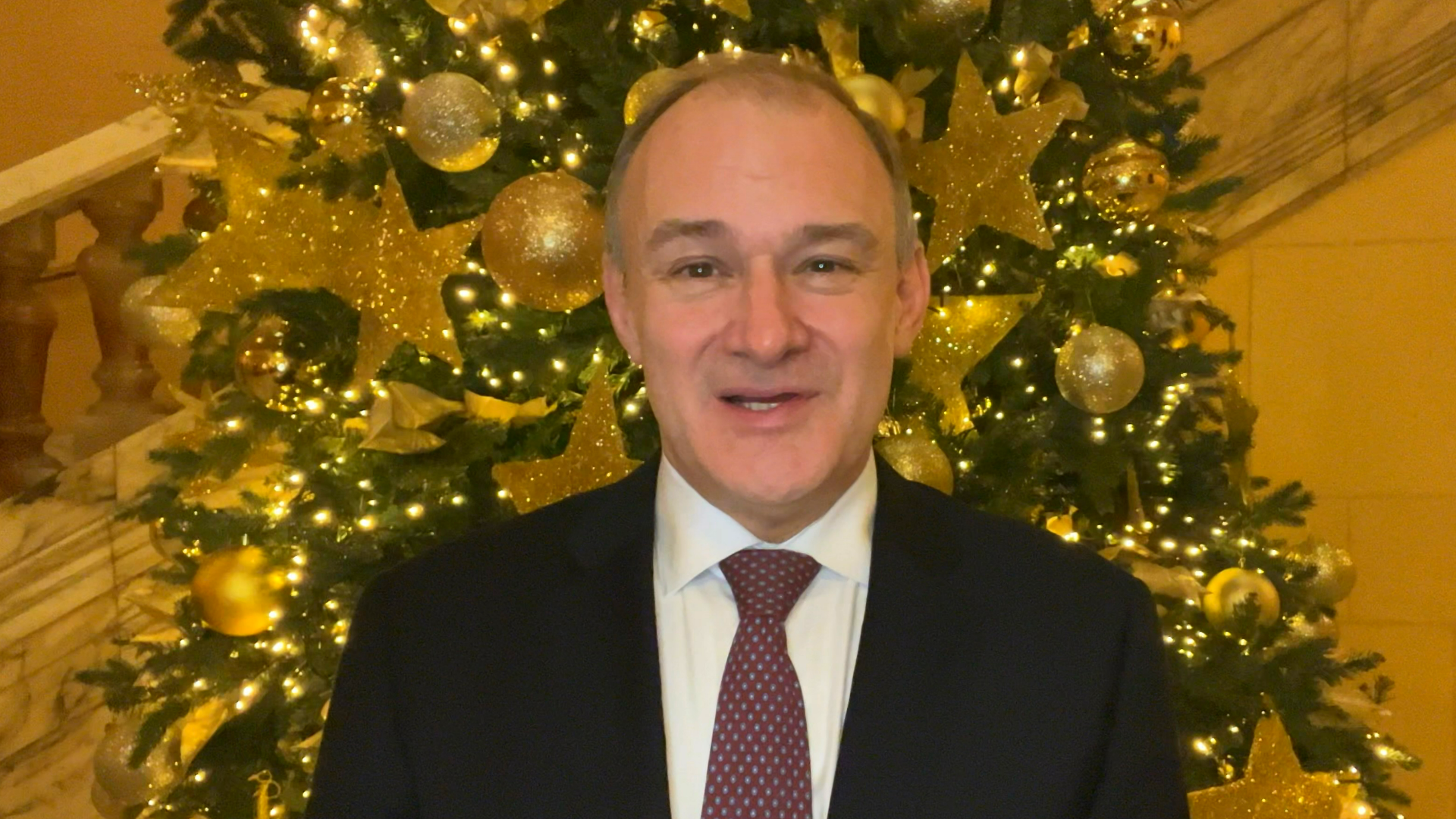 Ed Davey standing in front of a Christmas tree